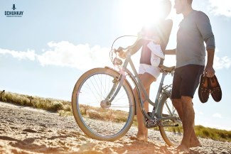 couple with bycicle at the beach