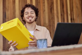 young man smiling about receiving a parcel by DHL